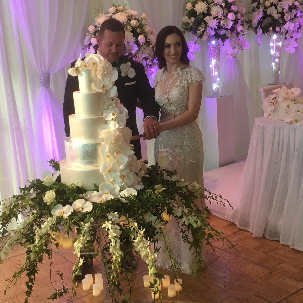 Wedding couple cutting a floral wedding cake