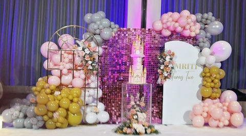 Pink shimmer wall with balloon backdrop and floral cake display
